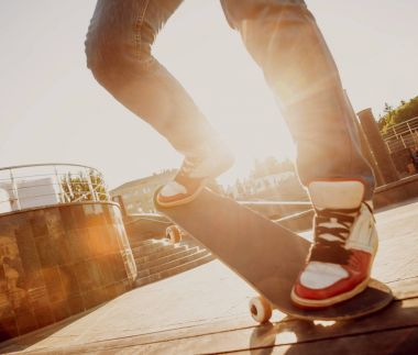 Genç adam kasaba meydanında kaykay sürme görüntü kırpılmış