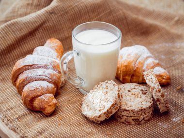 Süt, raller ve kruvasan çuval bezi üzerinde sağlıklı kahvaltı