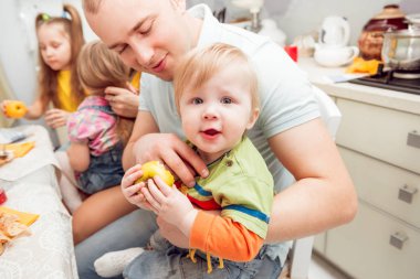 Neşeli aile öğle yemeği sırasında mutfakta eğleniyor