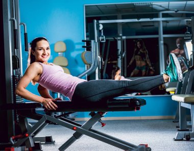 Genç esmer kadının spor salonunda egzersiz yapması