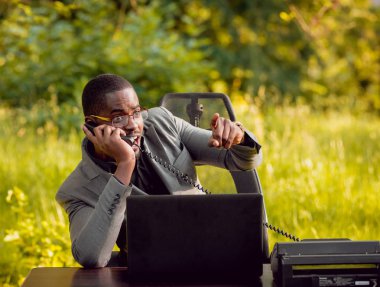 Park içinde İşte genç Afro-Amerikalı iş adamı. Uzak iş kavramı.