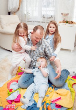 Baba evde çocuklarıyla oynuyor.