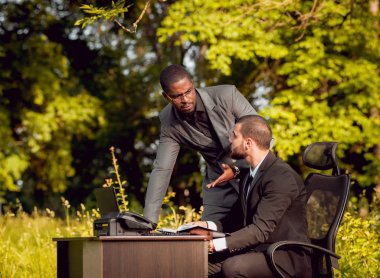 Parkta iş adlı iki genç çok kültürlü businessmans. Uzak iş kavramı.