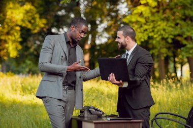 İki genç çok kültürlü iş adamları iş park yerinde. Uzak iş kavramı.