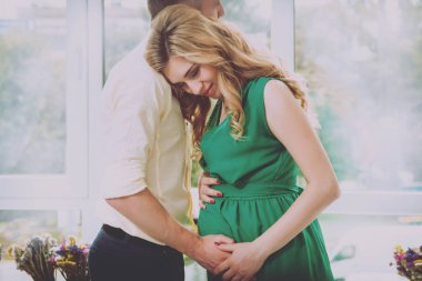 Genç hamile kadın ve kocası. Bebek için bekliyor