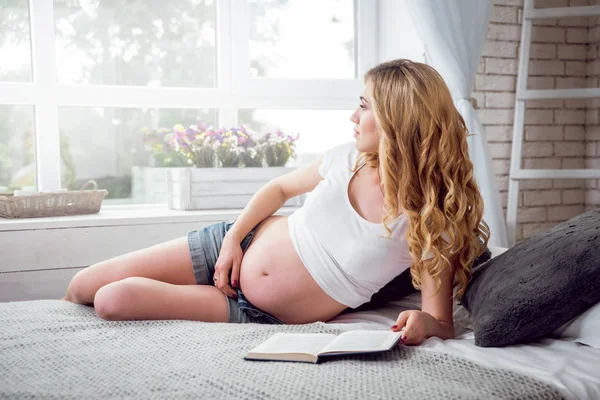 年轻孕妇读一本书 — 图库照片