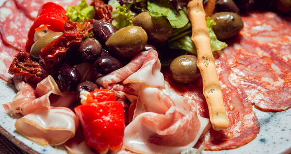sliced meat with various additions on a plate
