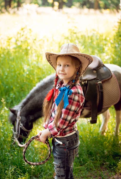 美丽的女孩在帽子与小马在公园里 — 图库照片
