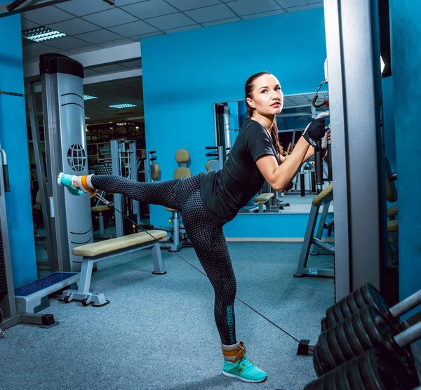 Genç esmer kadının spor salonunda egzersiz yapması.