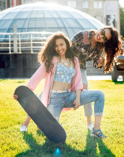 Genç esmer kız açık havada kaykay ile poz