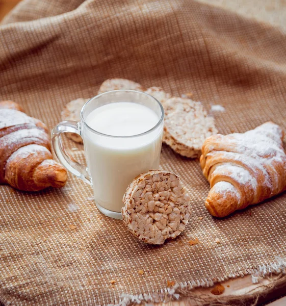 Süt, ekmek ve çuval bezi üzerinde kruvasan kahvaltı