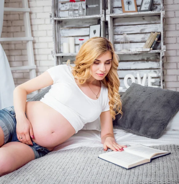 Genç hamile kadın bir kitap okuma