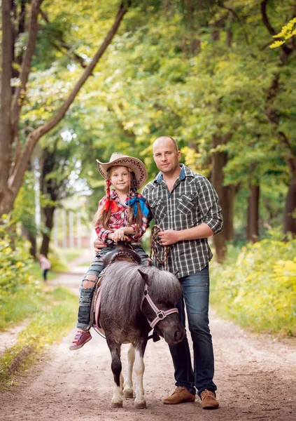 Malá Holčička Pony Jezdecké Kovbojský Klobouk Svým Otcem Parku — Stock fotografie