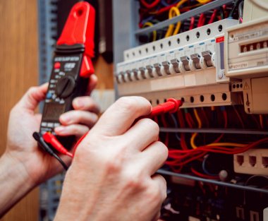 Elektrik donatımı. Elinde Tester.