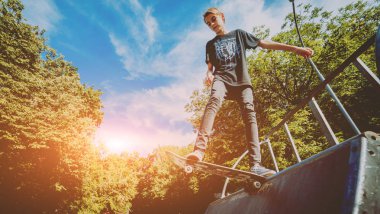 Skate park yapan genç kaykaycı.