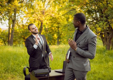 İki genç çok kültürlü iş adamları iş park yerinde. Uzak iş kavramı.