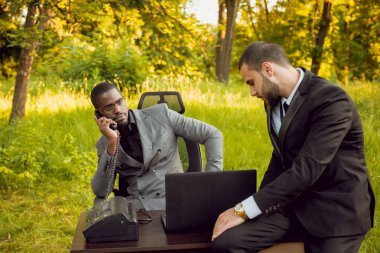 Parkta iş adlı iki genç çok kültürlü businessmans. Uzak iş kavramı.