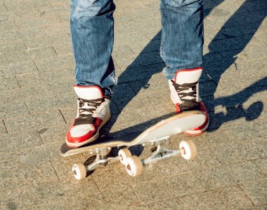 Genç adam kasaba meydanında kaykay sürme görüntü kırpılmış