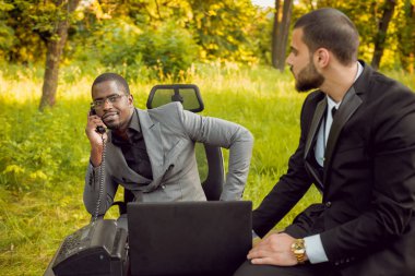 İki genç çok kültürlü iş adamları iş park yerinde. Uzak iş kavramı.