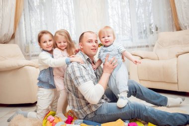 Baba evde çocuklarıyla oynuyor.