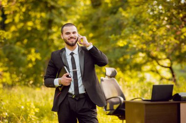 Genç işadamı park içinde işte. Uzak iş kavramı.