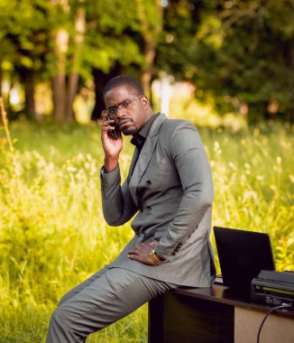 Park içinde İşte genç Afro-Amerikalı iş adamı. Uzak iş kavramı.