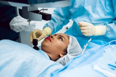 Genç Afro-Amerikan kadın görüşünü göz doktoru ile kontrol. Tıbbi donatımı.