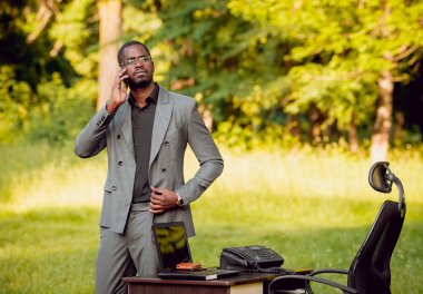 Park içinde İşte genç Afro-Amerikalı iş adamı. Uzak iş kavramı.