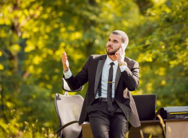Genç buisnessman Park'ta çalışma sakallı. Uzak iş kavramı.