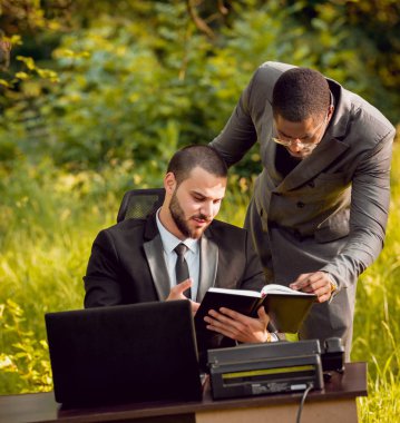 İki genç çok kültürlü iş adamları iş park yerinde. Uzak iş kavramı.