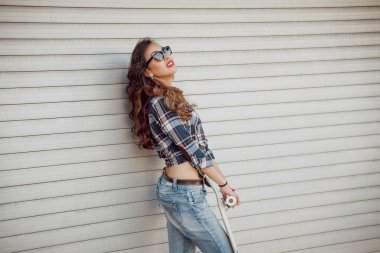 Genç esmer kız açık havada kaykay ile poz