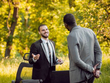 İki genç çok kültürlü iş adamları iş park yerinde. Uzak iş kavramı.