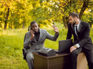 İki genç çok kültürlü iş adamları iş park yerinde. Uzak iş kavramı.