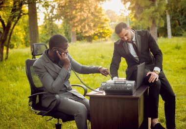 İki genç çok kültürlü iş adamları iş park yerinde. Uzak iş kavramı.