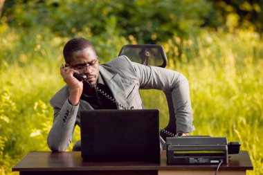 Park içinde İşte genç Afro-Amerikalı iş adamı. Uzak iş kavramı.