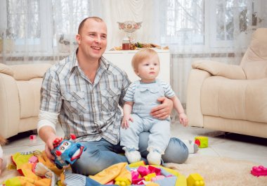 Baba evde oğluyla oynuyor.