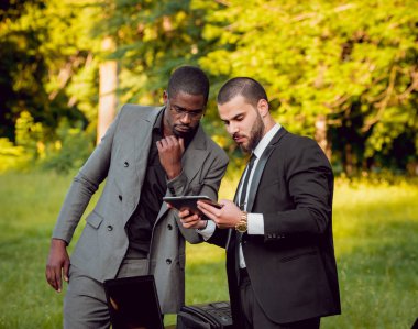 Parkta iş adlı iki genç çok kültürlü businessmans. Uzak iş kavramı.