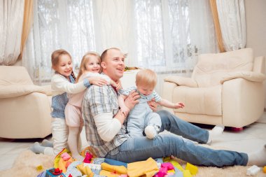 Baba evde çocuklarıyla oynuyor.