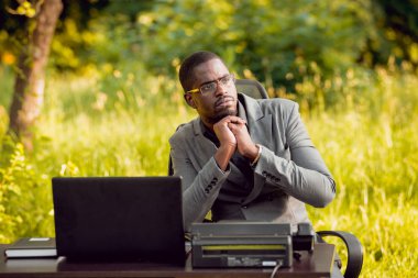 Park içinde İşte genç Afro-Amerikalı iş adamı. Uzak iş kavramı.