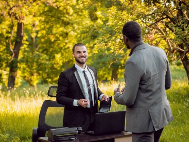 İki genç çok kültürlü iş adamları iş park yerinde. Uzak iş kavramı.