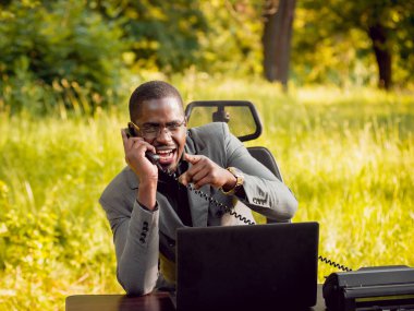 Park içinde İşte genç Afro-Amerikalı iş adamı. Uzak iş kavramı.