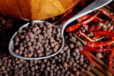 Bir kaşık ve defne yaprağı üzerinde bambu kara biber