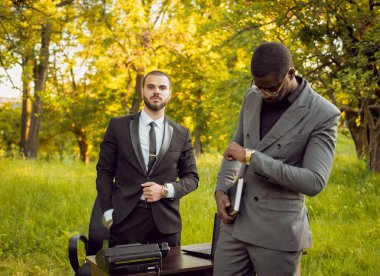 Parkta iş adlı iki genç çok kültürlü businessmans. Uzak iş kavramı.