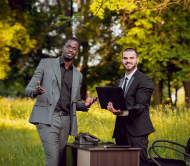 İki genç çok kültürlü iş adamları iş park yerinde. Uzak iş kavramı.