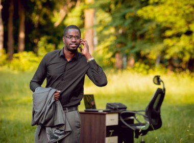 Park içinde İşte genç Afro-Amerikalı iş adamı. Uzak iş kavramı.