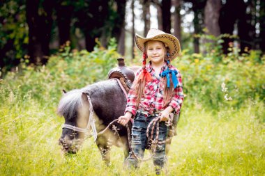 Park midilli sürme kovboy şapkalı örgü ile küçük kız