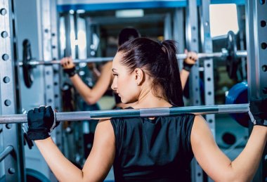 Genç esmer kadının spor salonunda egzersiz yapması