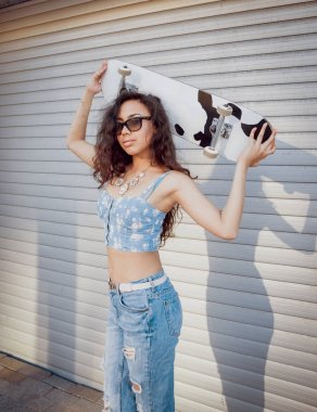 Gündelik kıyafeti açık havada kaykay ile poz Orta Doğu görünümü ile güzel kız