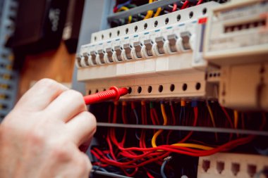 Elektrik donatımı. Elinde Tester.