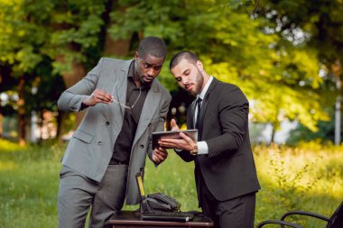 Parkta iş adlı iki genç çok kültürlü businessmans. Uzak iş kavramı.